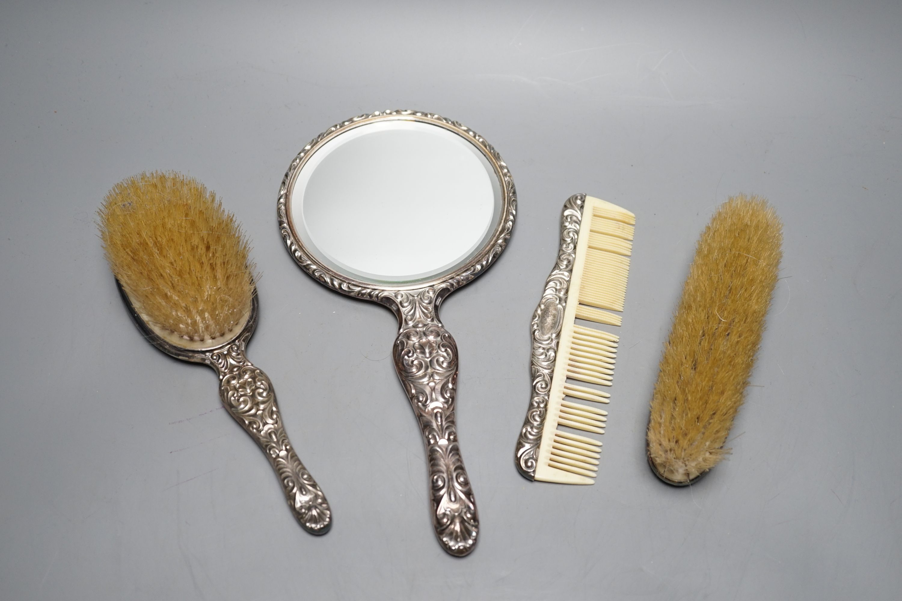 A continental 800 standard white metal mounted four piece mirror and brush set.